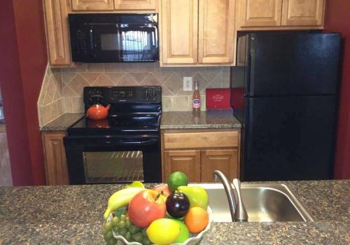 Kitchen with black appliances and a fruit bowl on the counter at Haverford Court apartments for rent
